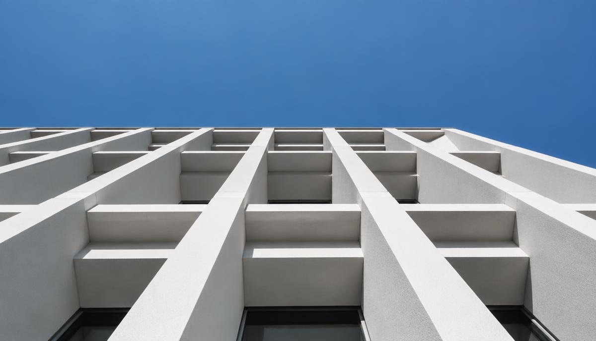 Geometric white building facade against a blue sky